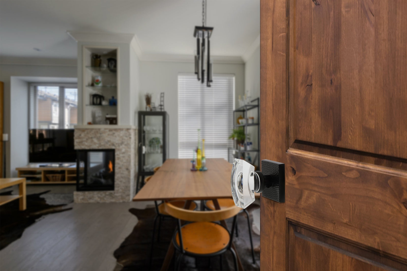 a wooden door into a modern home with black door hardware and crystal doorknob from viaggio