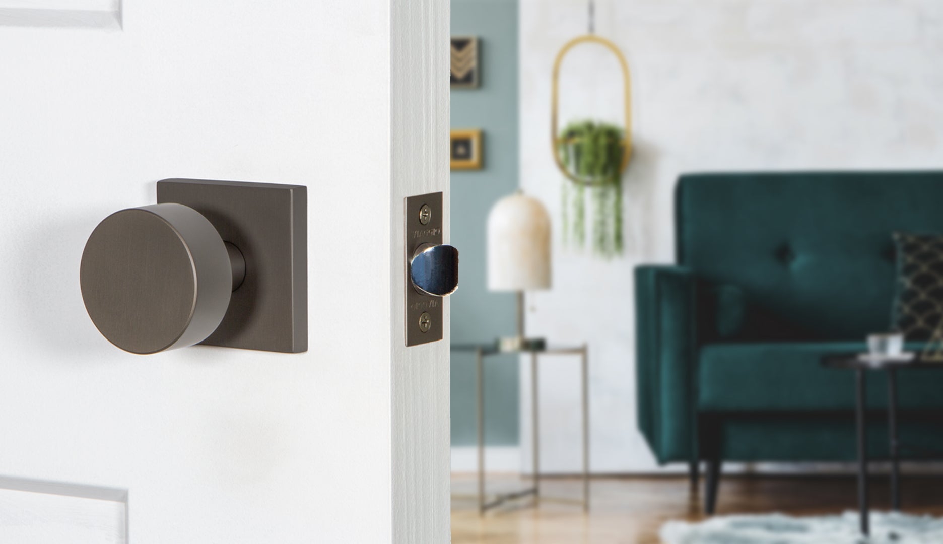 modern home living room with dark teal couch, a hanging plant, and titanium gray square and circular hardware from viaggio contemporary
